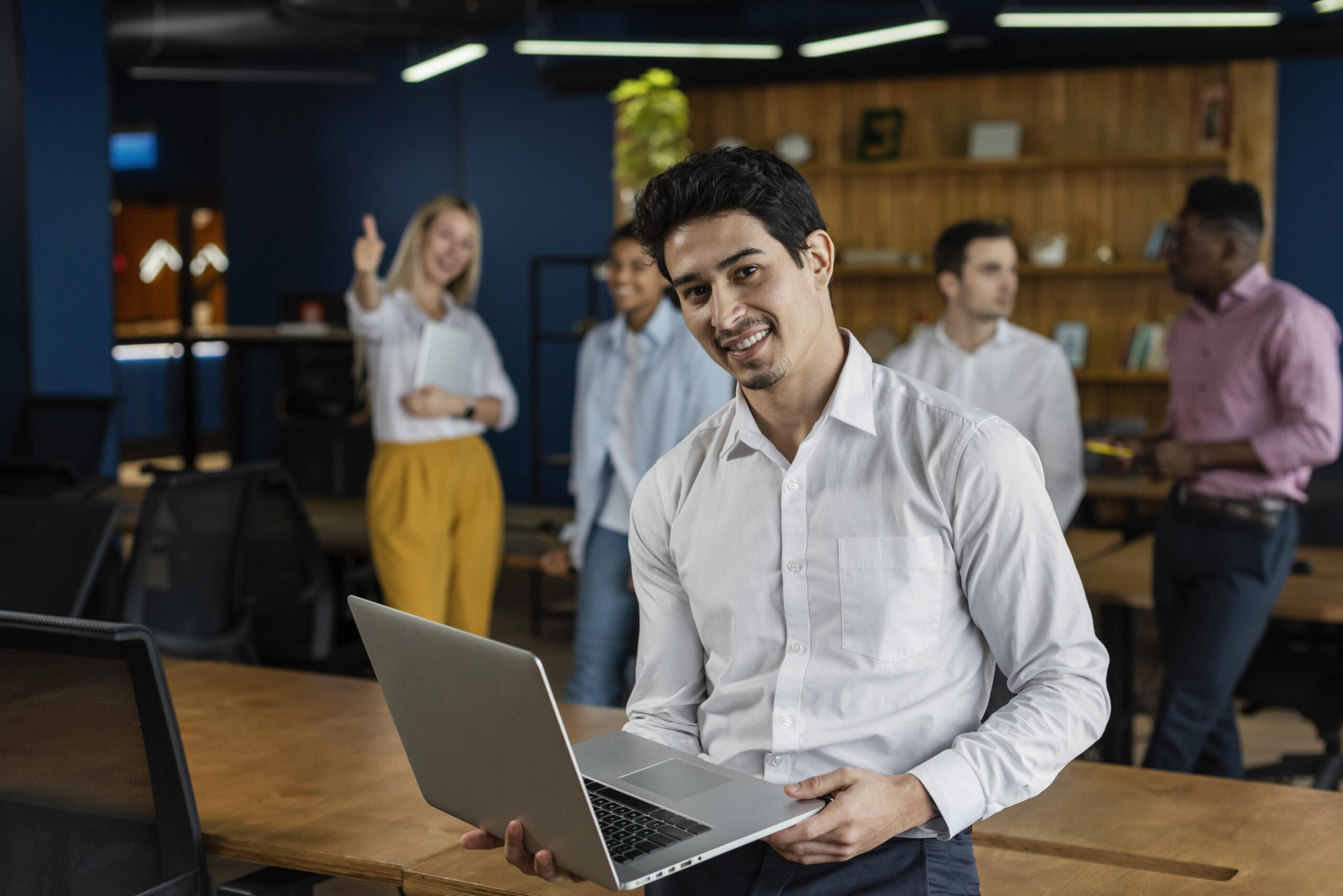 smiley man work holding laptop posing